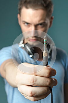Young guy holding stereo jack plug