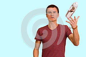 A young guy holds a bottle of water in his hand