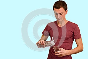 A young guy holds a bottle of water in his hand