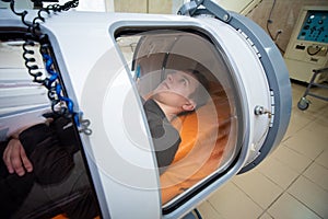 Young guy in a hyperbaric chamber, oxygen treatment photo