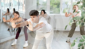 Young guy and international dancers preparing their modern dance performance at dance studio