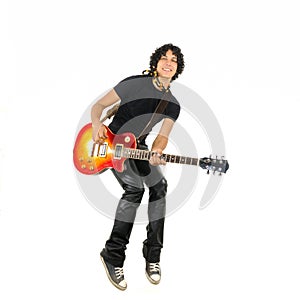 Young guy jumping with electric guitar