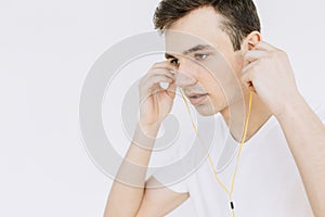 Young guy listening to music on headphones. Isolated white background