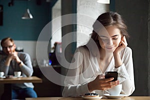 Young guy looking with interest at beautiful lady in cafe