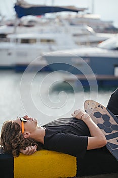 Young guy lying on skateboard spending time at skatepark