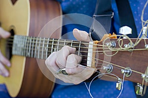 A young guy performs solo on a six-string guitar