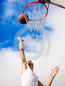 Young guy playing basketball. He is preparing to throw the ball