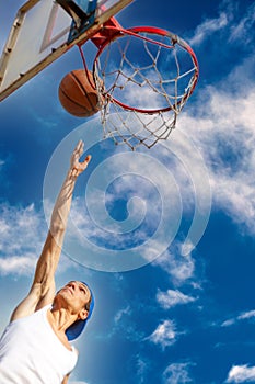 Young guy playing basketball. He is preparing to throw the ball in the basket