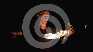 Young guy playing with fire. Dangerous stunt. Fire show