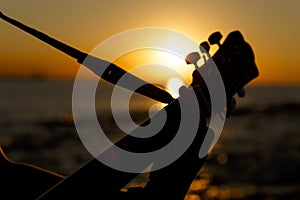 Young guy playing a guitar at sunset