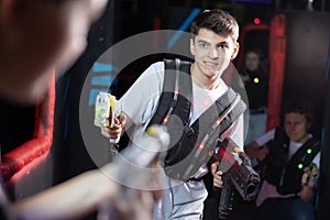 Young guy playing lasertag in arena