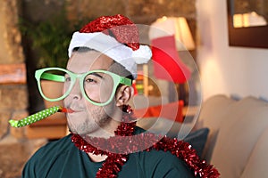 Young guy playing party horn blower during Christmas