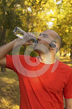 Young guy refreshing after exercise in park