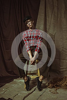 A young guy relaxes sitting on a chair