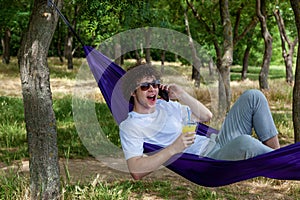 Young guy resting in a hammock in nature
