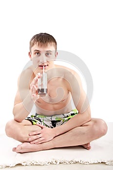 Young guy in shorts sitting with glass