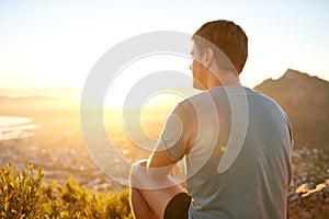 Young guy sitting on a nature trail at sunrise