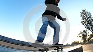 Young guy slides on a skateboard along the ledge, close up