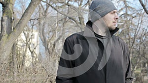 Young guy smokes at a park