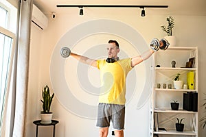 A young guy in sport wear is training at home