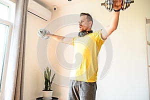 A young guy in sport wear is training at home