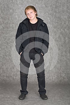 Young guy standing on a grey background