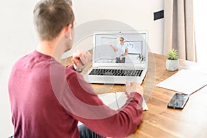 A young guy is studying online, watching webinars photo