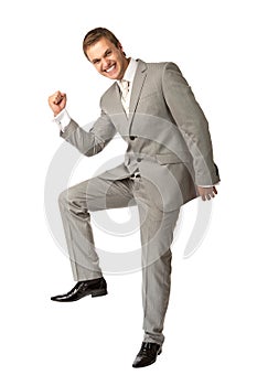 Young guy in suit clenching his fist in triumph