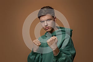 young guy in sweatshirt standing with boxing gesture