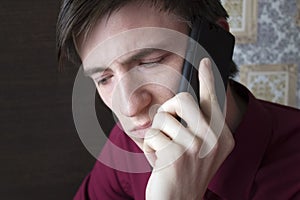 Young guy talking on the phone, looking down