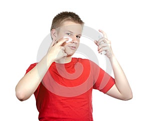 The young guy to put cosmetic cream on a face.Portrait on a white background