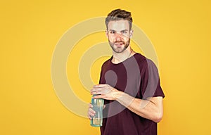 young guy with unshaven face and stylish hair drink water, sport