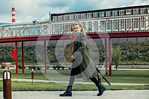 A young guy with a Viking hairstyle braided pigtails in a military coat and berets walks