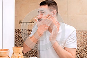 A young guy washing his face with gel. Personal care.