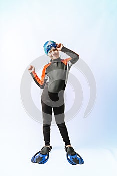 Young guy in a wetsuit, fins, glasses and a hat. Diving training