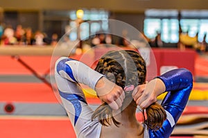 Young gymnast girl fixing hair before appearance