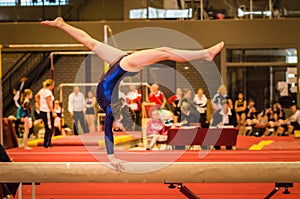 Young gymnast girl performing routine on balance b