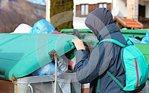 young gypsy looks for something to eat inside the bin