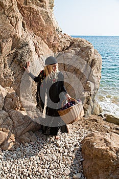 Young gypsy walking on the rocky beach