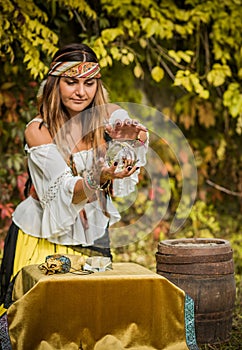 Young gypsy woman fortune teller concept with crystal ball