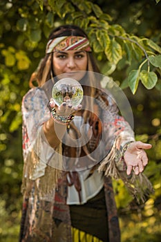 Young gypsy woman fortune teller concept with crystal ball