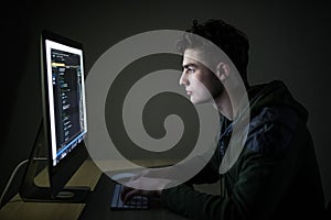 Young hacker in the dark breaks the access to steal information and infect computers and systems. concept of hacking and cyber ter