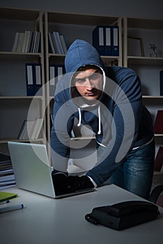 The young hacker hacking into computer at night