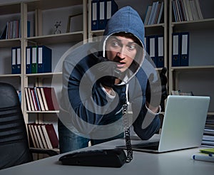 Young hacker hacking into computer at night