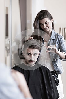 Young hairdresser and male customer