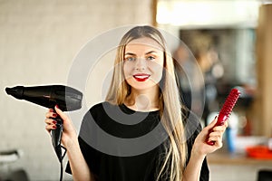 Young Hairstylist Holding Blow Dryer and Hairbrush