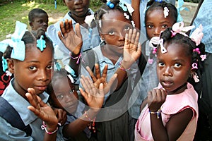 Young Haitian school children show friendship bracelets in village.