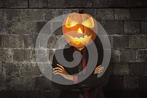Young halloween man wearing suit with pumpkin head