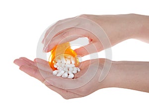 Young hand pouring many pills into other hand, isolated