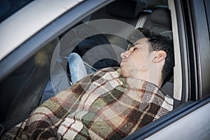 Young handosme man sleeping in his car